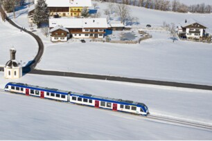 Zug der Bayerischen Regiobahn in Winterlandschaft als Vogelperspektive