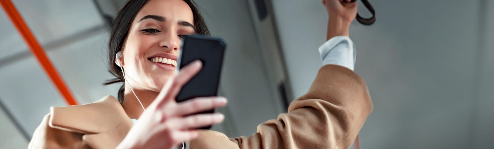 Eine Frau schaut auf ihr Handy in einem Zug.
